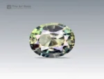 Oval cut 1.2 carat sapphire from Nigeria showing subtle yellow, green, and blue flashes on a neutral background