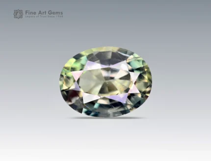 Oval cut 1.2 carat sapphire from Nigeria showing subtle yellow, green, and blue flashes on a neutral background