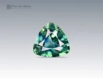 Trilliant cut 1.5 carat sapphire gemstone from Nigeria showing green and blue hues on a neutral background