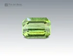 3.8 carat Pakistani peridot with emerald cut, featuring natural ludwigite inclusions.