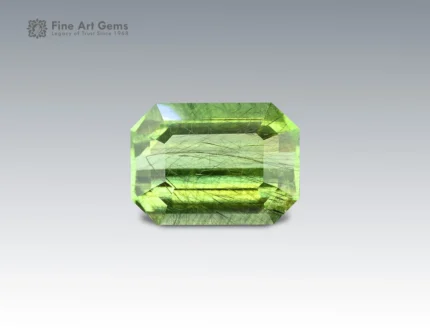 3.8 carat Pakistani peridot with emerald cut, featuring natural ludwigite inclusions.