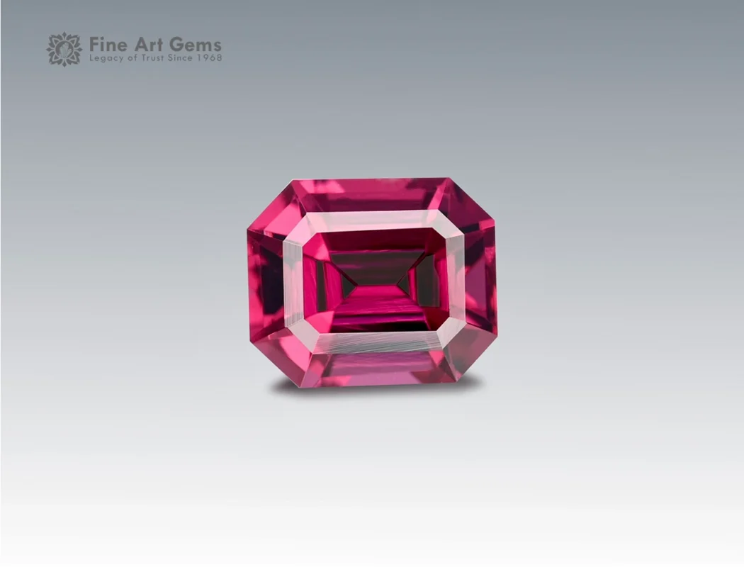 A 2.1 carat emerald-cut Rhodolite Garnet from Africa with deep raspberry-red brilliance, perfect for jewelry.
