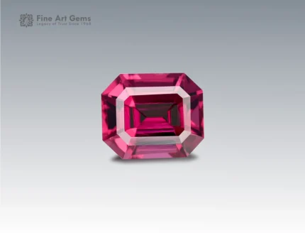 A 2.1 carat emerald-cut Rhodolite Garnet from Africa with deep raspberry-red brilliance, perfect for jewelry.