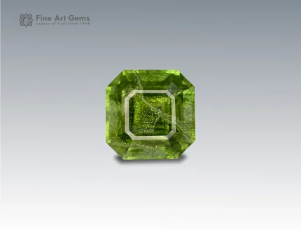 A 5.45 carat Asscher-cut Peridot from Pakistan with unique Ludwigite inclusions, glowing in vibrant green, perfect for collectors and jewelry.