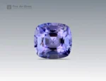 A 0.6 carat cushion-cut Parti Sapphire from Nigeria with vivid violet-blue tones, perfect for fine jewelry.