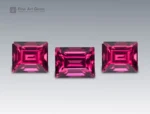 Brilliant 6 carat rhodolite garnet from Africa, expertly cut in baguette style, displaying vivid raspberry-red hues with sharp step facets and radiant luster.