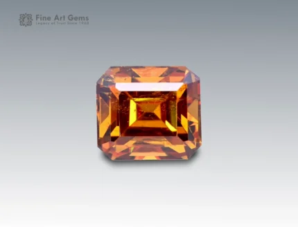 Brilliant 2-carat emerald cut sphene (titanite) gemstone with golden-orange brilliance, sourced from Pakistan. Rare and collectible gemstone for jewelry and gem enthusiasts.