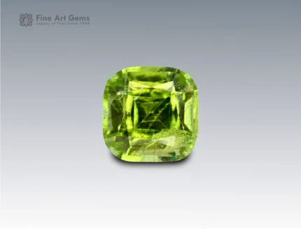 Cushion-cut vivid green peridot gemstone weighing 5.10 carats from Pakistan, featuring distinctive ludwigite needle inclusions.