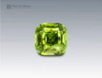 Cushion-cut vivid green peridot gemstone weighing 5.10 carats from Pakistan, featuring distinctive ludwigite needle inclusions.