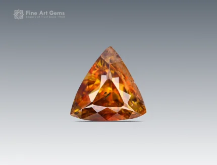 Brilliant 01-carat trillion-cut sphene (titanite) gemstone from Pakistan, showing vivid golden-orange fire, ideal for jewelry, rings, pendants, or gemstone collections.