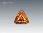 Brilliant 01-carat trillion-cut sphene (titanite) gemstone from Pakistan, showing vivid golden-orange fire, ideal for jewelry, rings, pendants, or gemstone collections.