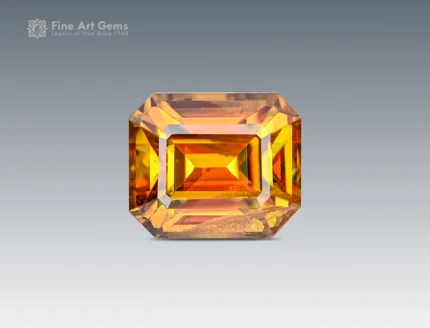 1.85 carat emerald cut sphene (titanite) gemstone from Pakistan, showing golden-orange color and brilliant sparkle