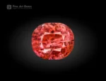 Cushion-cut vayrynenite gemstone from Pakistan displaying rosy red to raspberry color with natural internal features.
