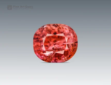 Cushion-cut vayrynenite gemstone from Pakistan displaying rosy red to raspberry color with natural internal features.