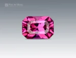 Natural 0.75 carat emerald-cut rhodolite garnet displaying a vibrant raspberry-pink color and slight inclusions from Africa.