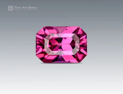 Natural 0.75 carat emerald-cut rhodolite garnet displaying a vibrant raspberry-pink color and slight inclusions from Africa.